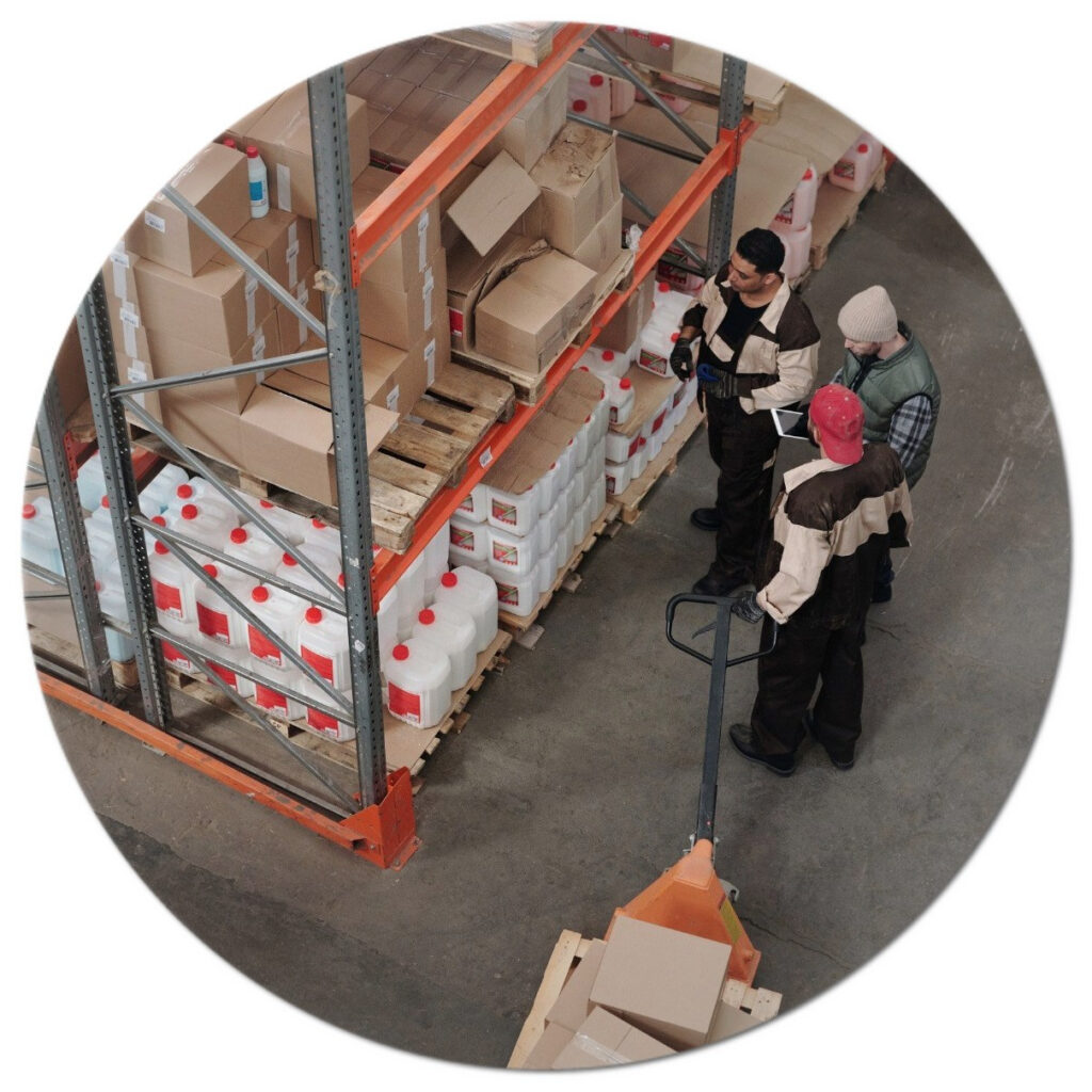 A group of people in a warehouse looking at boxes.