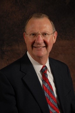 A person smiling wearing black suit